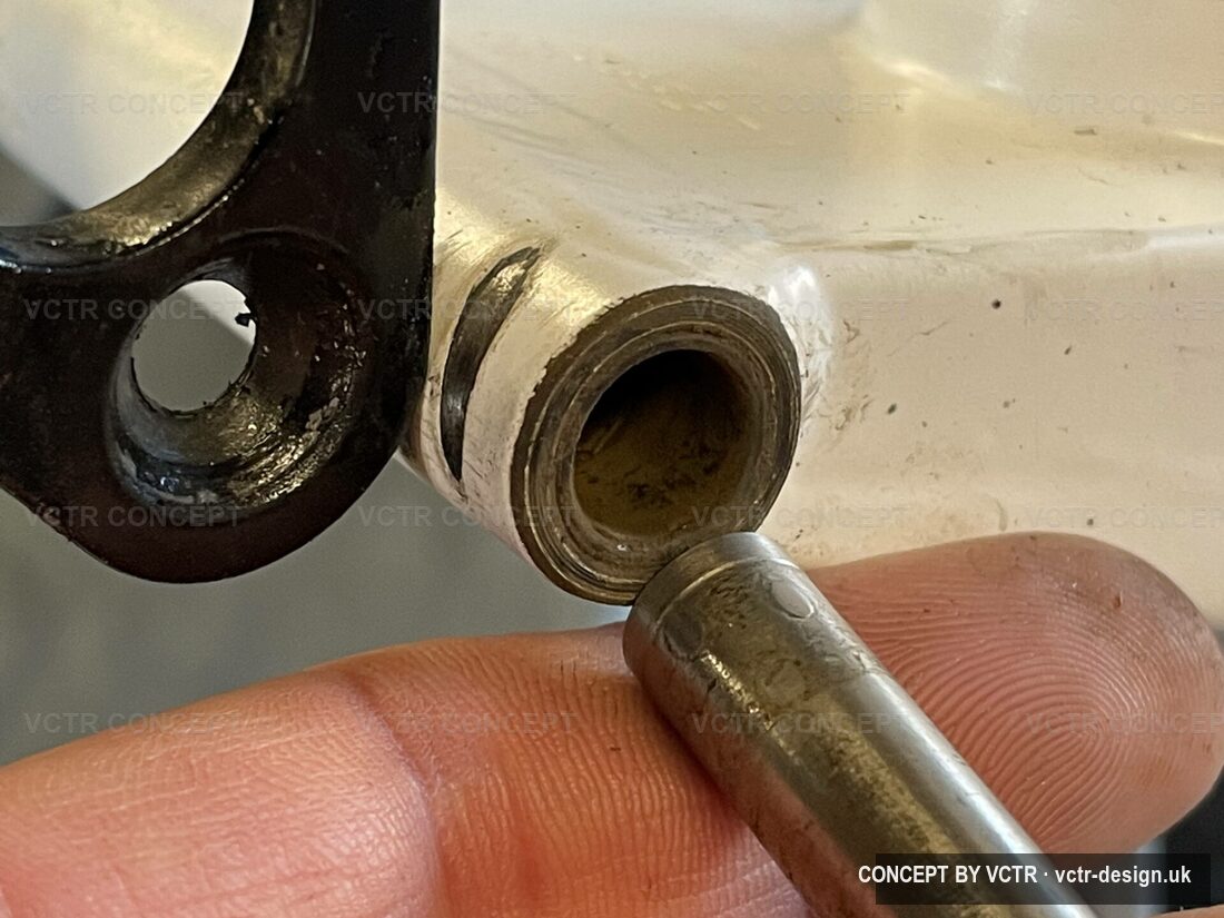 A worn Brompton rear hinge bush held in the hand